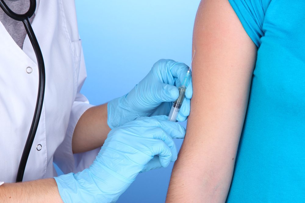 Doctor giving vaccination into arm