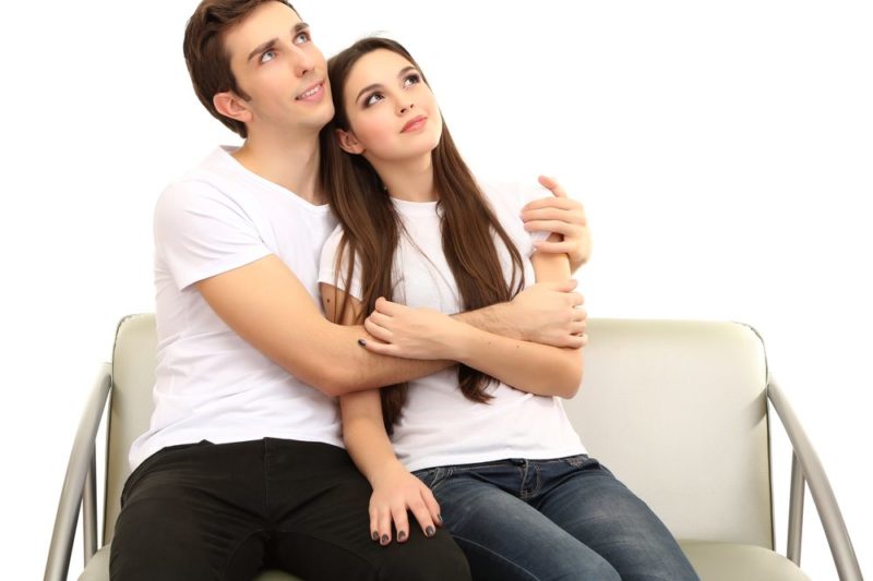 young couple sitting closely on couch