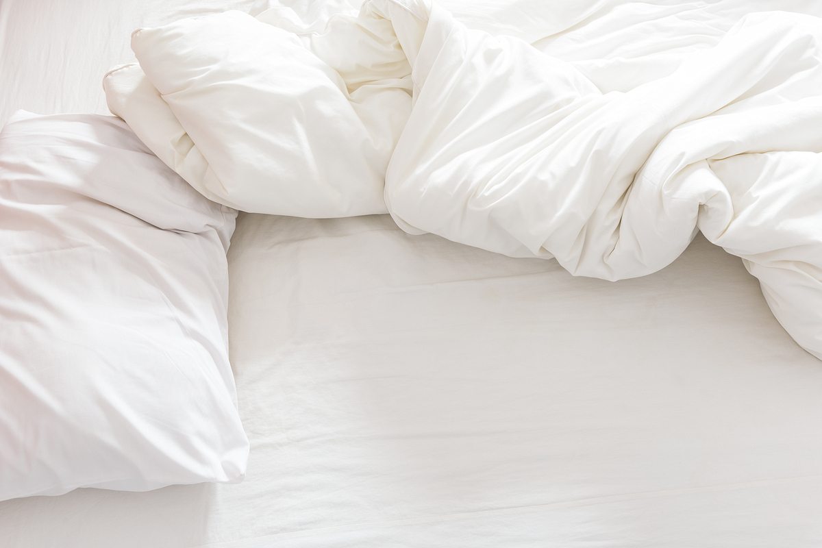 Кровать с белым постельным бельем сверху