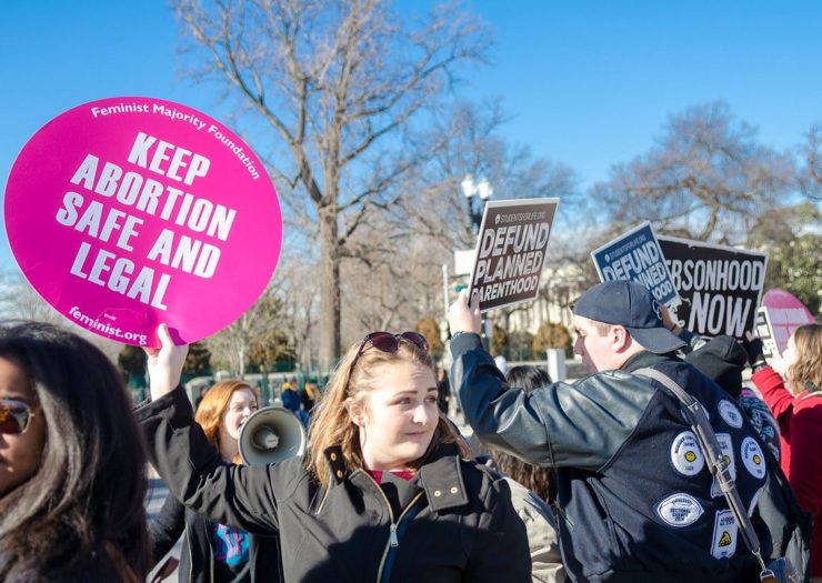 [Photo: A Pro-Choice activist holds up a sign that reads 