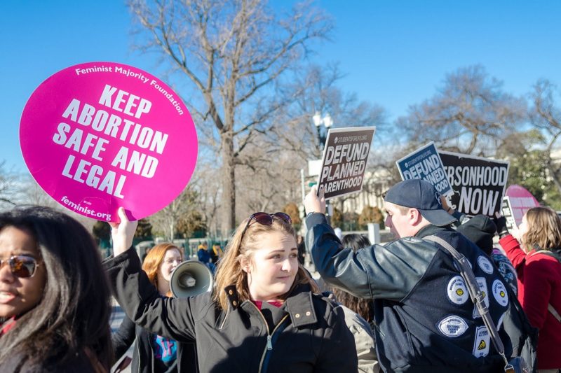 [Photo: A Pro-Choice activist holds up a sign that reads