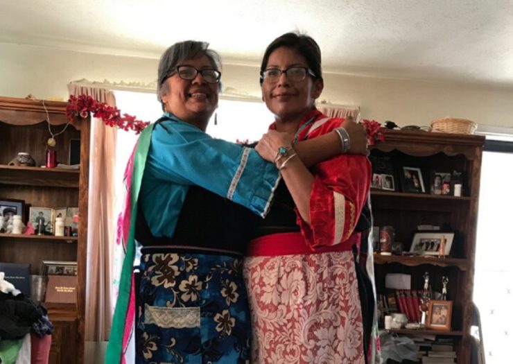 [Photo: Leigh Ann Lorenzo and her sister, Kari Ray, model their traditional Laguna dress. Its two layers and belt are typically paired with moccasins and worn to ceremonies—but the dress' wrapping make it difficult to undo quickly for easy breastfeeding]