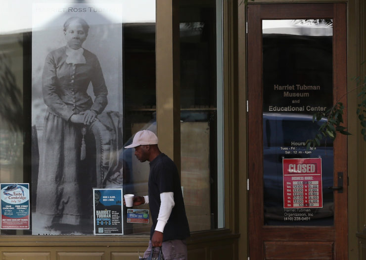 [Photo: Man walks past the Harriet Tubman Museum.]