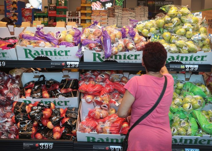 [Photo: A customer looks at different fruit in a supermarket]