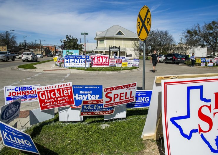 [Photo: Election signage is littered across a lawn in Texas.]