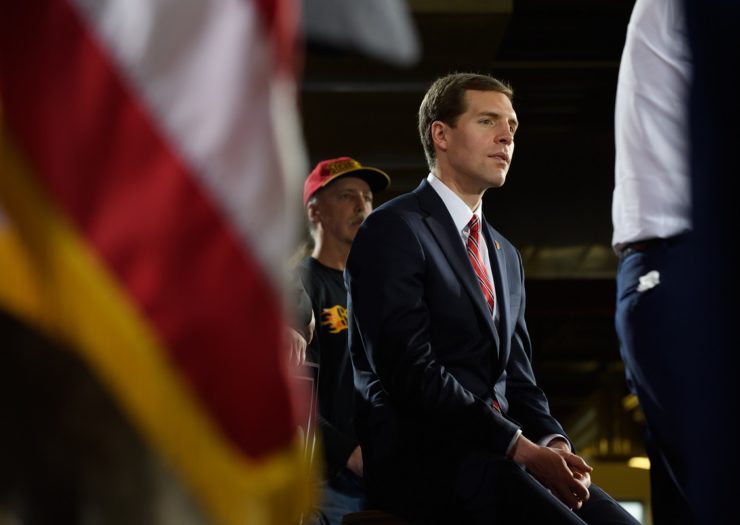 [Photo: Democratic congressional candidate Conor Lamb sits and listens to a speech.]