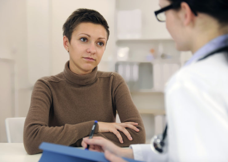 [Photo: A woman looks at her doctor.]
