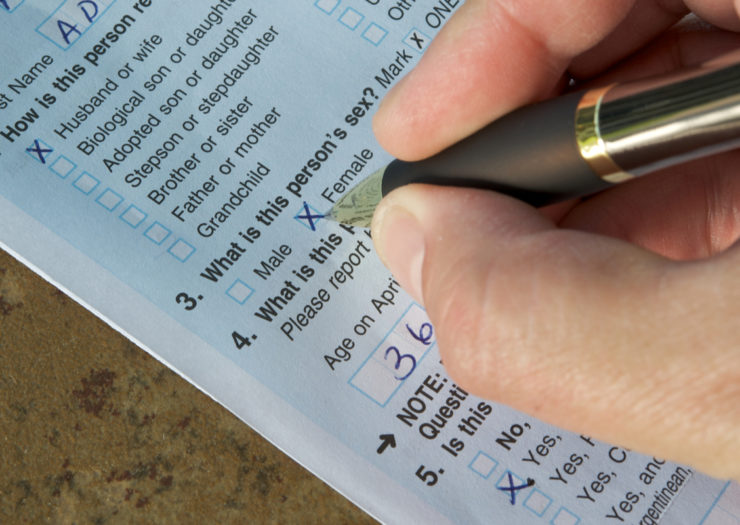 [Photo: a person filling out a form with a pen]