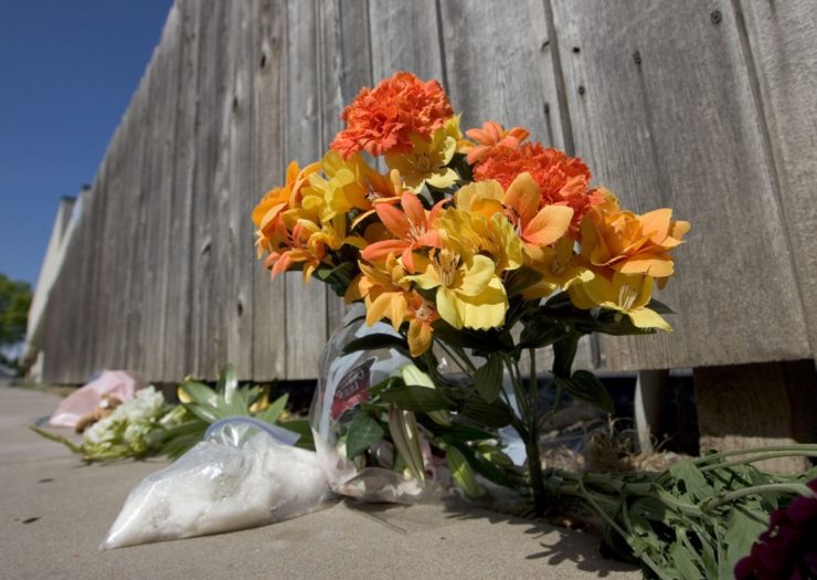 [Photo: Flowers sit in front of the fence at Women's Health Care Services abortion clinic ]