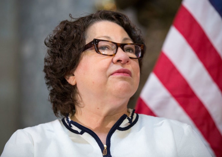 [photo: Justice Sonia Sotomayor standing in front of an American flag.]