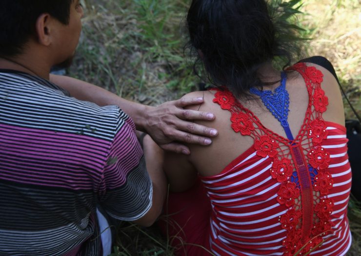 [Photo: Undocumented people sit outside]