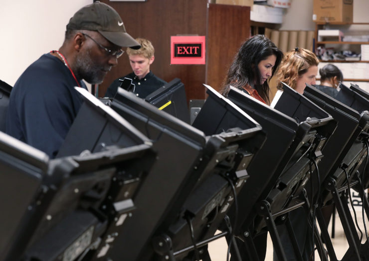 [photo: voters case early ballots in north carolina in 2016]