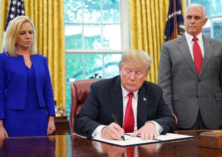 [Photo: Homeland Security Secretary Kirstjen Nielsen and Vice President Mike Pence watch as President Donald Trump signs an executive order]