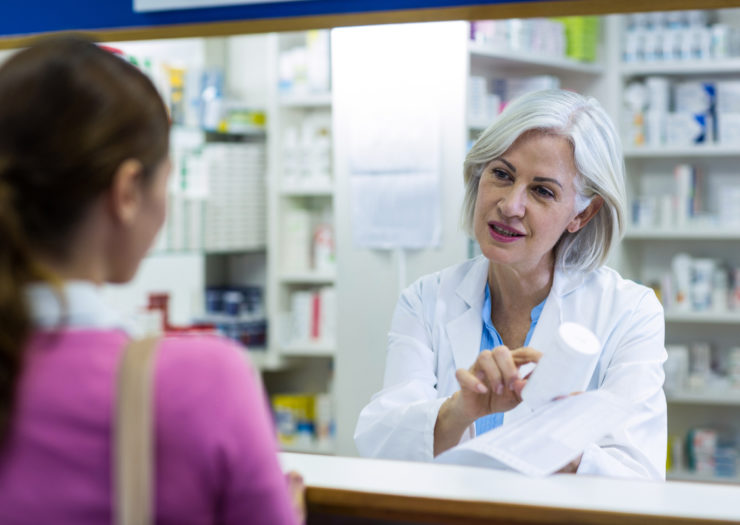 [Photo: A pharmacist speaks with a customer]