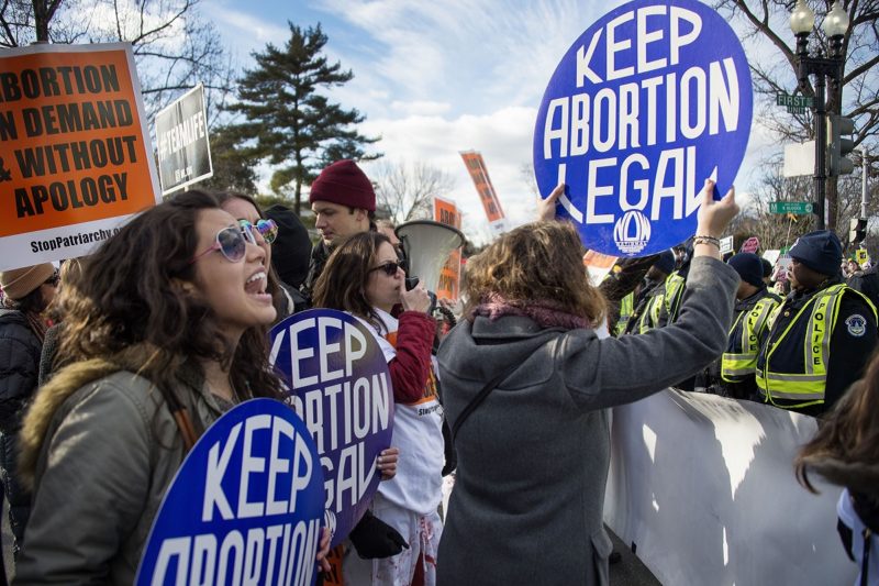 [Photo: Pro-Choice activists hold up signs that read