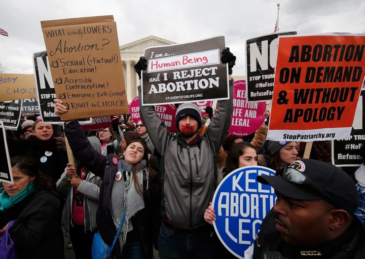 [Photo: Pro-Choice activists hold posters to block anti-choice signs at a March for Life rally]