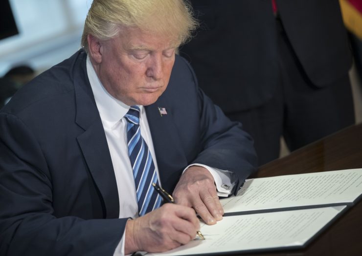 [Photo: President Donald Trump signs an executive order]