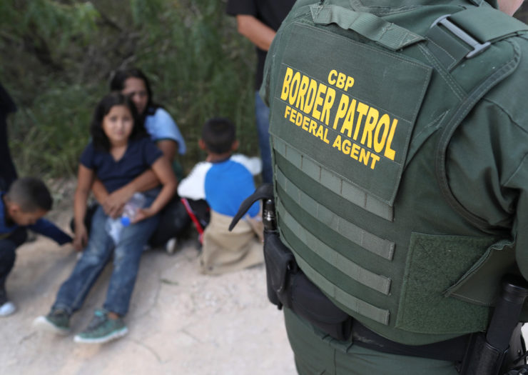 [Photo: Central American asylum seekers wait as U.S. Border Patrol agents take them into custody on June 12, 2018 near McAllen, Texas.]
