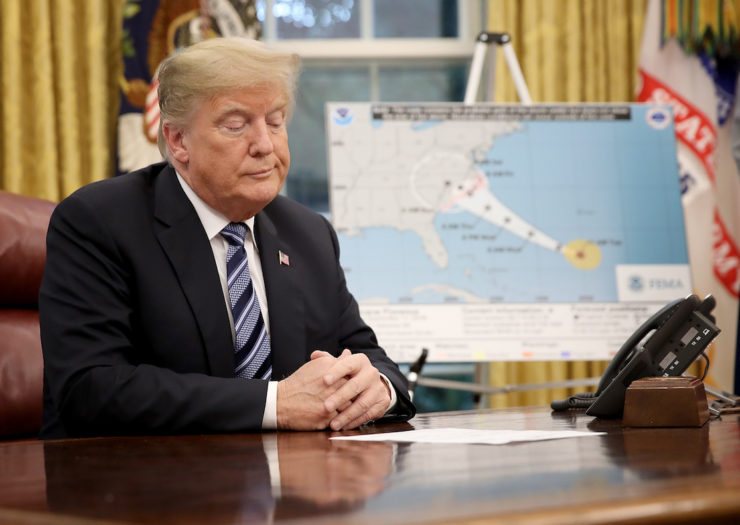 [Photo: President Trump sits at Oval Office desk next to map of Hurricane Florence's approach to southeast coast.]