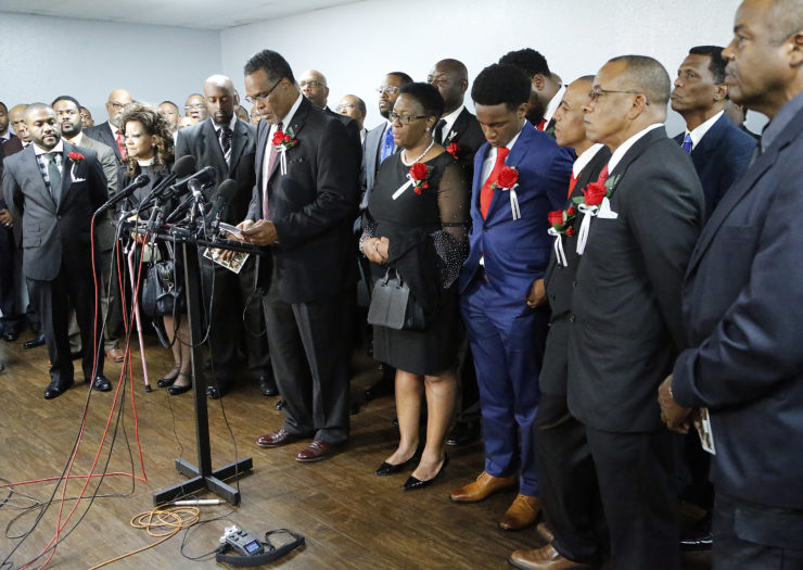 [photo: members of Botham Jean's family stand with church members at a funeral service for Jean in Richardson, Texas.]