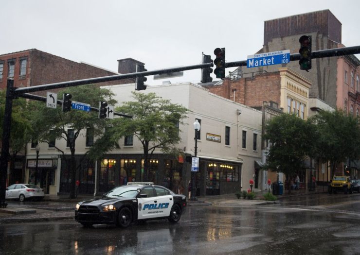 [Photo: A police car drives through an intersection after the traffic lights went out as rain from Hurricane Florence falls in Wilmington, North Carolina on September 13.]