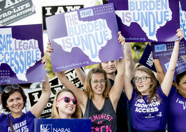 [Photo: Abortion rights activists hold up signs that read 