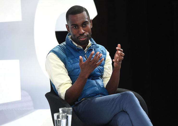 [photo: DeRay Mckesson speaks on a stage at an event.]