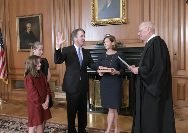 [Photo: Kavanaugh stands with his two daughters and his wife as John Roberts swears him in]