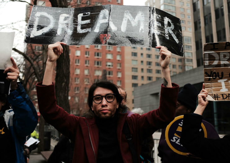 [Photo: An activist carries a sign that says 