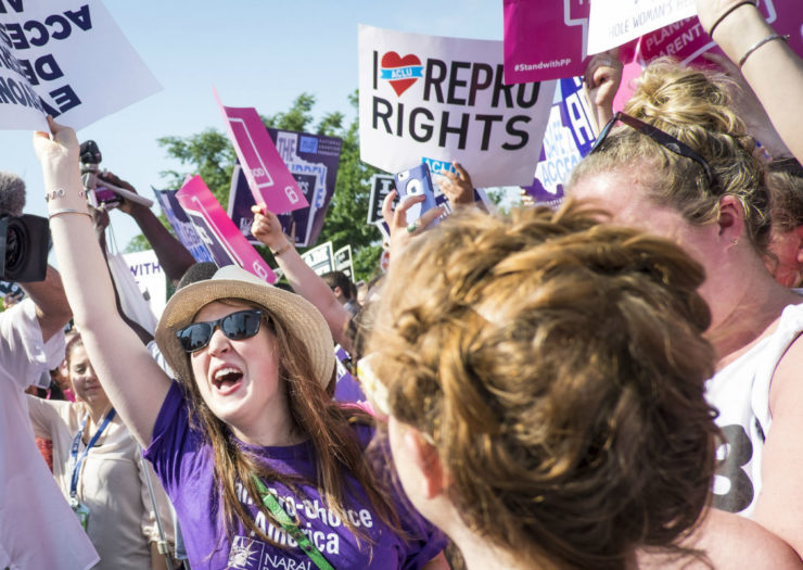 [Photo: Pro-choice advocates holding signs referencing reproductive rights.]