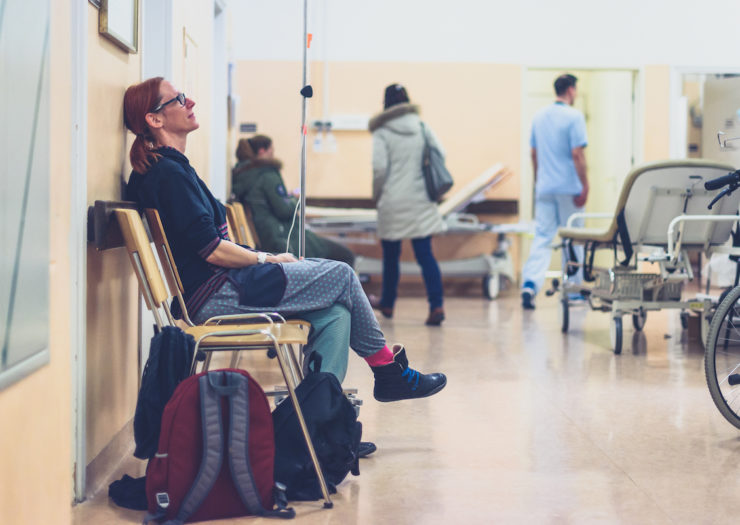 [Photo: Woman sitting in hospital waiting room.]