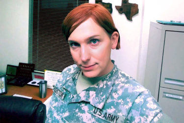 [Photo: Kathryn Goldston smiles as she takes a picture of herself in uniform.]