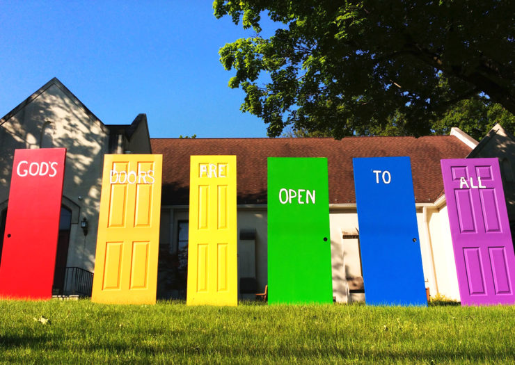 [Photo: On the lawn of a church, a word painted on each door - doors of different shapes, sizes, and colors - come together to say, `God`s Doors Are Open To All`.]