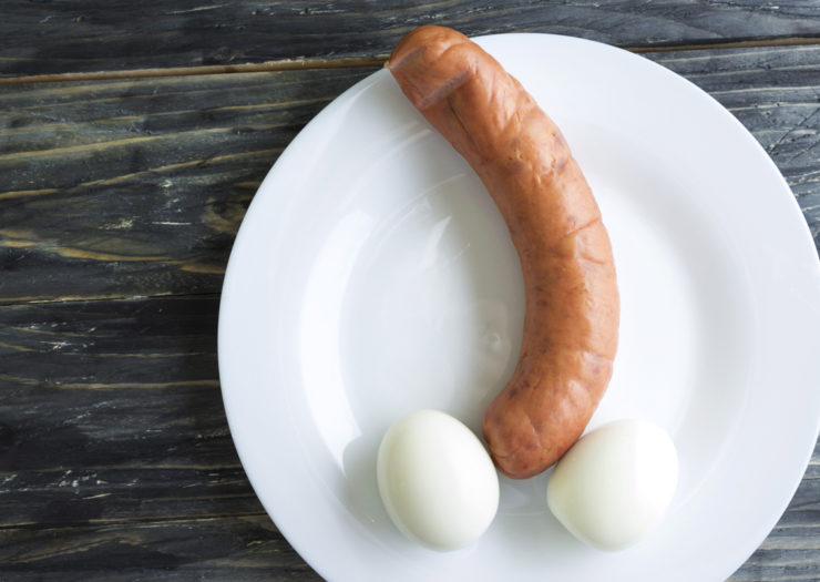 [Photo: A bent sausage and chicken eggs on a white plate.]