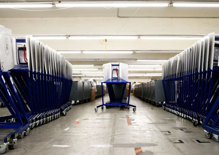 [Photo: Voting booths sit at a voting machine facility warehouse.]