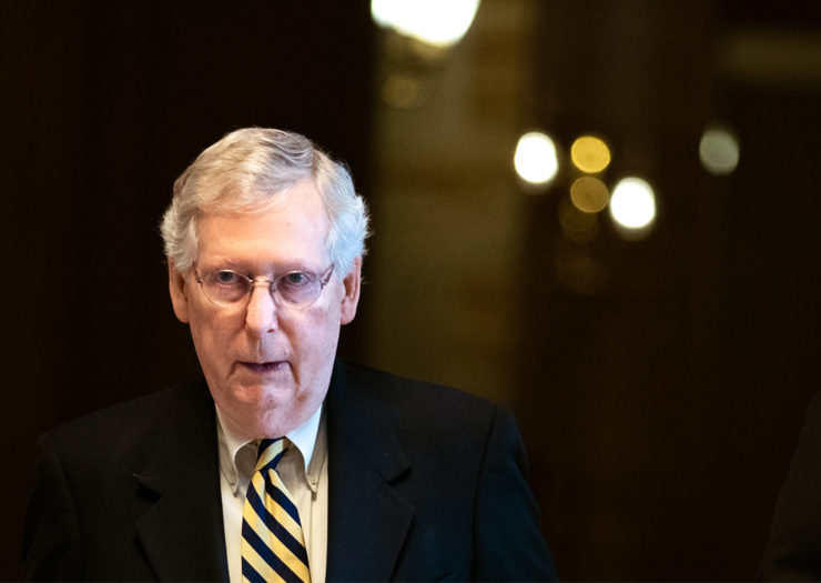[Photo: Senate Majority Leader Mitch McConnell walks to a meeting.]