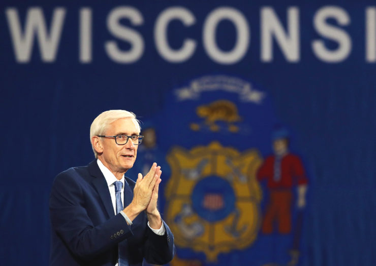 [Photo: Wisconsin Governor Tony Evers speaks at a rally.]