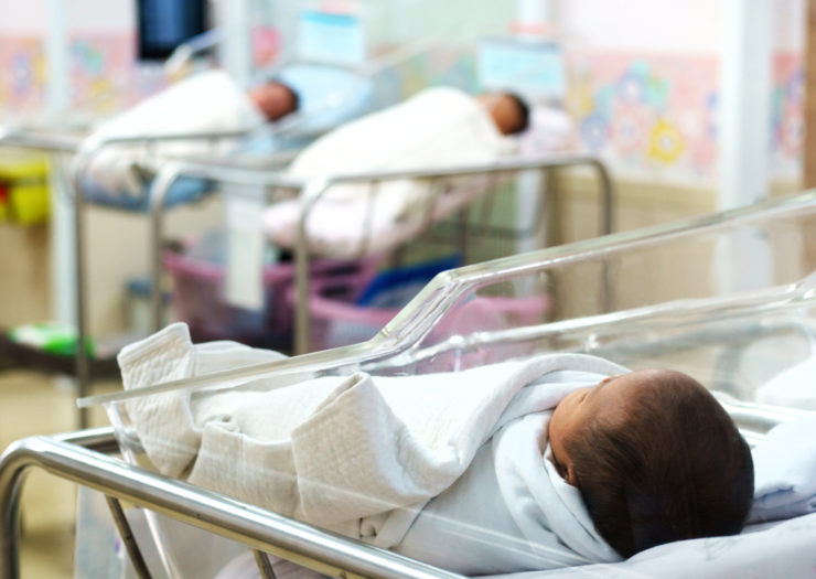 [Photo: A newborn baby in a hospital.]