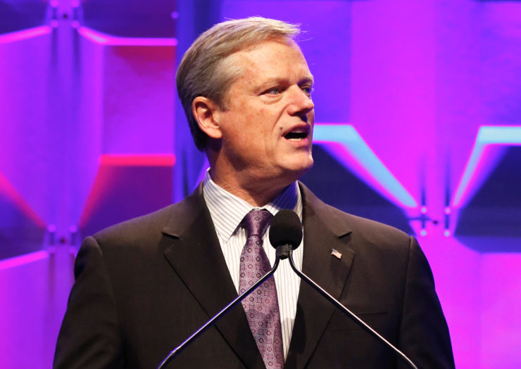 [Photo: Massachusetts Governor Charlie Baker speaks on stage during an event.]
