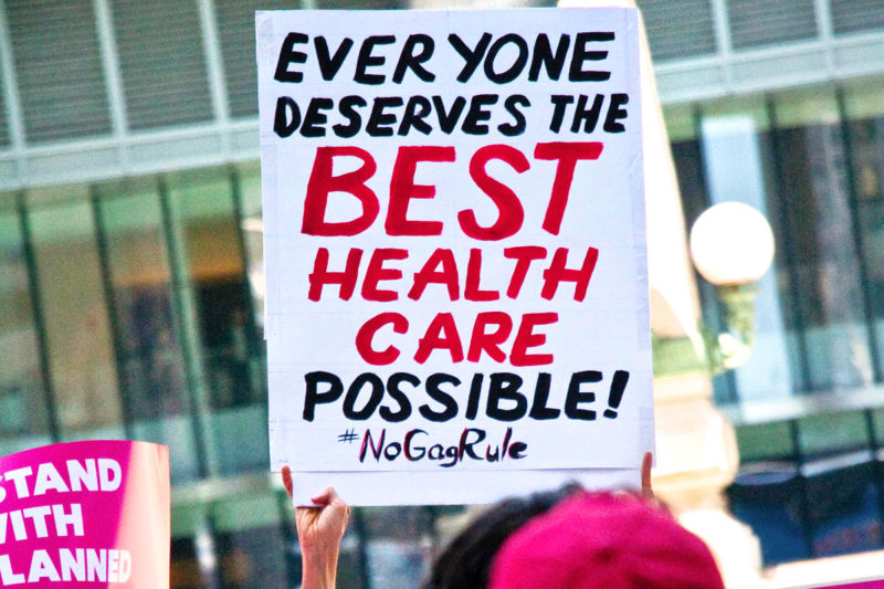 [Photo: A group of pro-choice supporters hold signs as they protest the gag rule.]