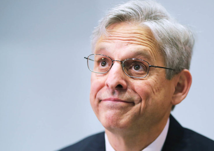 [Photo: Merrick Garland gestures with a puzzled face as he pauses during a conversation.]