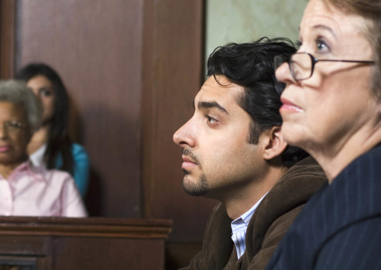 [Photo: Side view of legal observers and advocates in a courtroom during a hearing.]