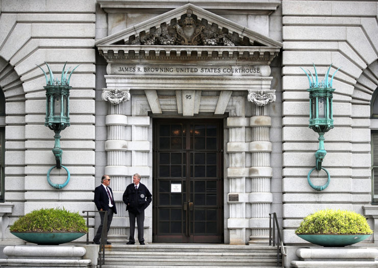 [Photo: Security guards stand in front of the Ninth U.S. Circuit Court of Appeals.]