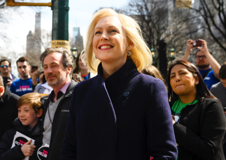 [Photo: Kristen Gillibrand smiles as she awaits the kick-off of an event.]