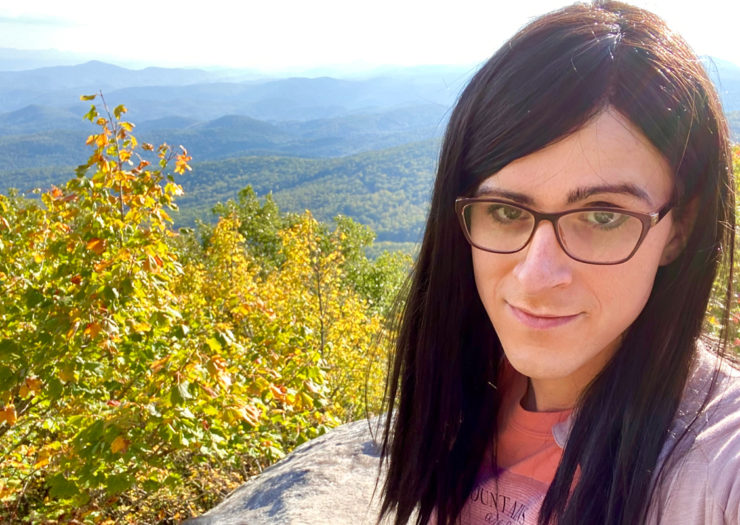 [Photo: Erin Reed poses in front of a mountainous landscape.]