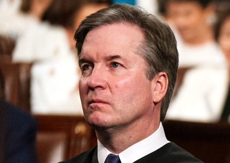 [Photo: Supreme Court Justice Brett Kavanaugh listens on during an event.]