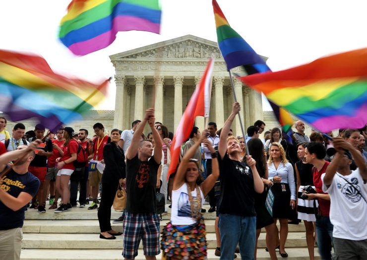 [Photo: People hold Pride flags as they celebrate outside the Supreme Court in Washington, DC on June 26, 2015 after its historic decision on gay marriage.]