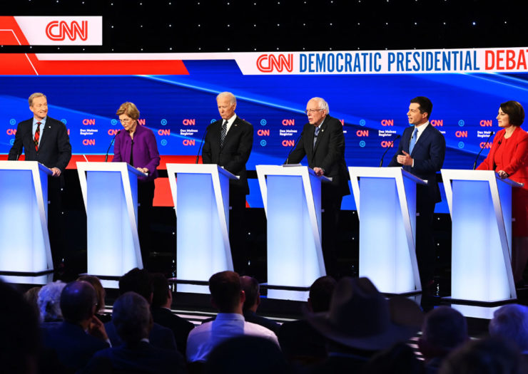 [Photo: The 2020 Democratic presidential hopefuls stand on stage during the 7th xemocratic debate in Iowa.]