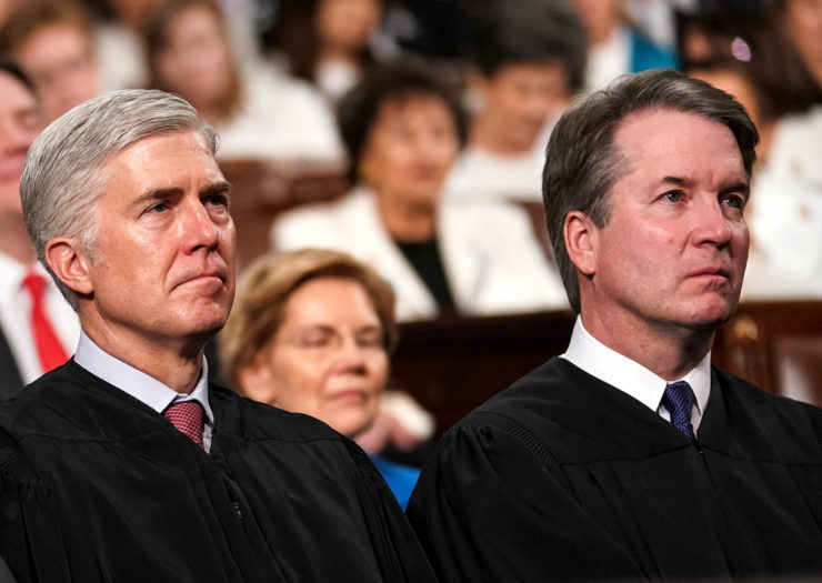 [Photo: Supreme Court Justices Neil Gorsuch and Brett Kavanaugh listen intently during a ceremony.]