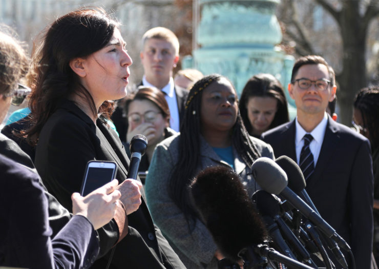 [Photo: Attorney Julie Rikelman speaks in front of a crowd during an outdoor press conference.]